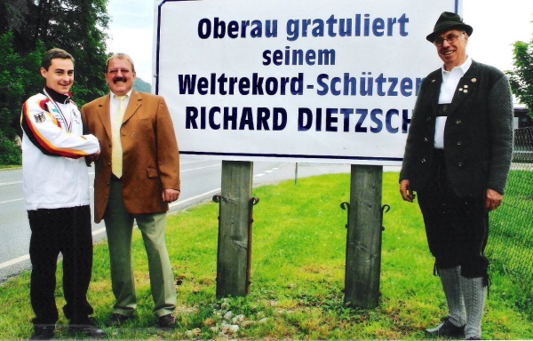 Foto Richard Dietzsch mit Bürgermeister Imminger und 1. Schützenmeister Hans Huber am Ortsschild mit Gratulationstafel zum Weltrekord